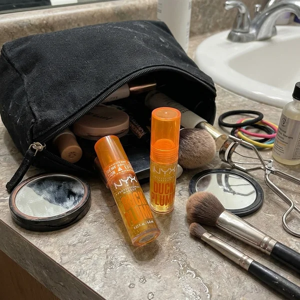 Foto de la clienta: neceser de maquillaje abierto con los dos glosses